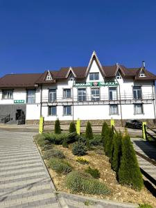 een groot wit gebouw met een bruin dak bij Готель Чертур in Yavory