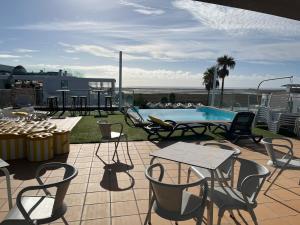 a patio with chairs and a table and a pool at Rainha Juliana in Fuzeta