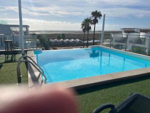 a swimming pool on the roof of a building at Rainha Juliana in Fuzeta
