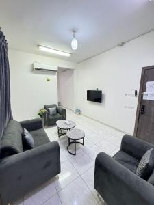 a living room with couches and a flat screen tv at شقق طرابزون المخدومة in Rumāḩ