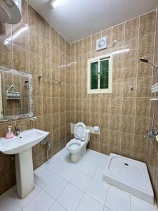 a bathroom with a toilet and a sink at شقق طرابزون المخدومة in Rumāḩ +19 photos