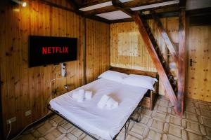 Bett in einem Zimmer mit Schild an der Wand in der Unterkunft Rifugio di Famiglia a due minuti dalle piste - Parcheggio e Wifi Gratuito in Sauze d'Oulx