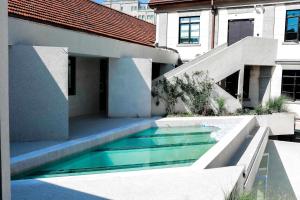 a swimming pool in the side of a house at 烟台朝阳文保艺术酒店 in Yantai