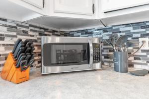 a microwave oven sitting on a counter in a kitchen at Central Oshkosh Stay - Walk to Lake and Downtown in Oshkosh