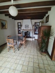a living room with a table and a fireplace at Le Gite de l'Alambic in Vanzay