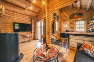 - un salon dans une cabane en rondins avec une table dans l'établissement Cosy Cottage w/ Jacuzzi in Amazing Region, à Aywaille