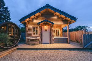 un chalet en rondins avec une terrasse et une porte dans l'établissement Cosy Cottage w/ Jacuzzi in Amazing Region, à Aywaille