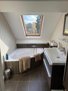 a bathroom with a tub and a sink and a window at Maison d'hôte Yourehome 2 belles chambres à louer individuellement dans un écrin de verdure in La Hulpe +7 photos