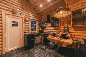 une cuisine avec une table dans une cabane en rondins dans l'établissement Cosy Cottage w/ Jacuzzi in Amazing Region, à Aywaille 18 autres photos