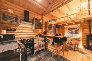 une cuisine dans une cabane en rondins avec un poêle dans l'établissement Cosy Cottage w/ Jacuzzi in Amazing Region, à Aywaille