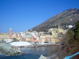uma cidade numa colina ao lado de um corpo de água em Casa al mare con parcheggio em Génova