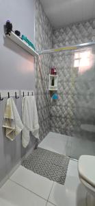 a bathroom with a shower with a toilet and towels at Mecejana Home in Boa Vista