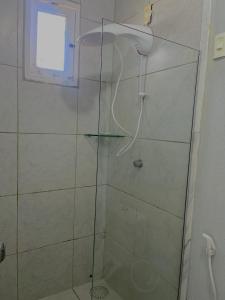 a shower with a glass door in a bathroom at Orla Pousada & Café in Parnamirim