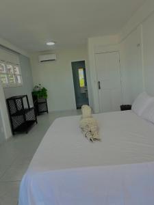 a stuffed animal laying on top of a large bed at Orla Pousada & Café in Parnamirim