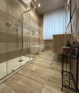 a bathroom with a glass shower and a tub at Le Manzé in Torremaggiore