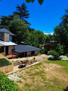 ビジャ・ヘネラル・ベルグラーノにあるPequeño chalet con frente al arroyoのベンチと木の庭のある家