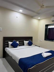 Un dormitorio con una cama grande con almohadas azules. en Hotel 31 Manor, en Nagpur