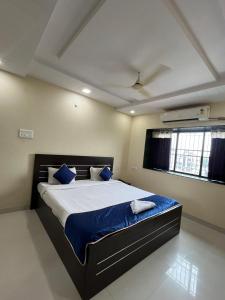 Un dormitorio con una cama grande con almohadas azules. en Hotel 31 Manor, en Nagpur