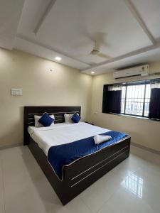 Un dormitorio con una cama grande con almohadas azules. en Hotel 31 Manor, en Nagpur