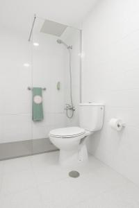 a white bathroom with a toilet and a shower at Apartamentos las Góndolas in Playa del Ingles