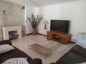 a living room with a flat screen tv on a wooden entertainment center at Le Gite de l'Alambic in Vanzay
