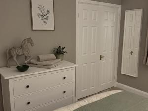 a white dresser with a horse statue on top of it at Number 30 The ORCHARDS in Middlewich