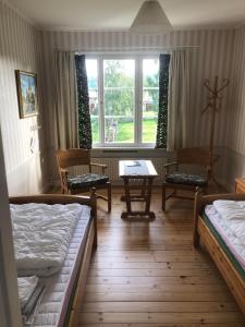 EdsbynSTF Vandrarhem Edsbyn的有两张床、一张桌子和几把椅子的房间