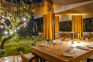 a dining room with a wooden table with chairs at Noah's Forest Hotel by Tifakara in Fortuna