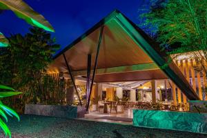 a house with a roof that is lit up at night at Noah's Forest Hotel by Tifakara in Fortuna +57 photos