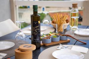 a table with a bottle of wine and a plate of food at Apartment Darka 1 in Sumartin