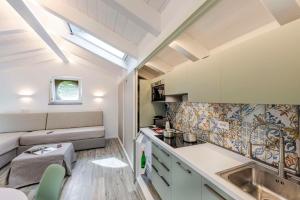 a small kitchen with a sink and a couch at Agave Apartment in Vico Equense +33 photos