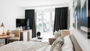 a living room with a couch and a tv at COSMOPOLITAN APARTMENTS Zürich Seefeld in Zürich