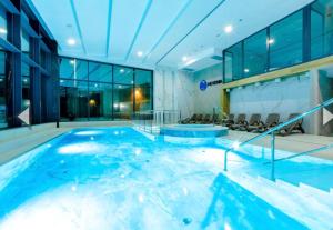 a large swimming pool in a building at Hevenia Klifowa 5 B Apartament 33 in Rewal