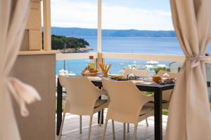 a dining table with chairs and a view of the ocean at Apartment Darka 1 in Sumartin +28 photos
