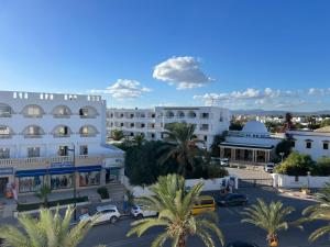 an aerial view of a large white building with palm trees at Résidence aladin in Hammamet Sud