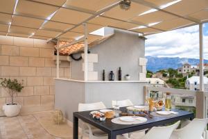 a patio with a black table and white chairs at Apartment Darka 1 in Sumartin
