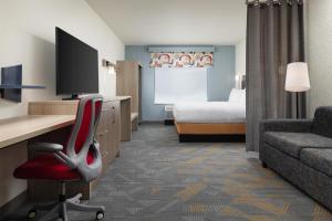 a hotel room with a desk and a chair and a bed at Home2 Suites By Hilton Cleveland, TN in Cleveland