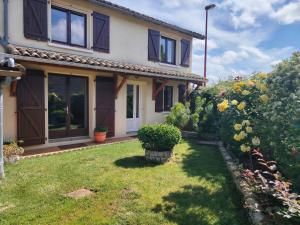 a house with a yard with plants and flowers at Le Gite de l'Alambic in Vanzay