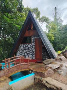 Una pequeña cabaña de madera con una piscina delante. en Cinnamon Leaf Leisure Resort, en Badureliya