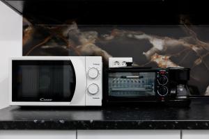 a microwave and a toaster oven on a counter at Urban Retreat 1BDR Craiova in Bordeiu
