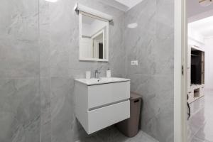 a bathroom with a white sink and a mirror at Urban Retreat 1BDR Craiova in Craiova +19 photos