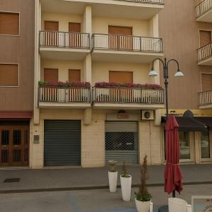 an apartment building with two balconies and an umbrella at IL CENTRO rooms in Cerignola