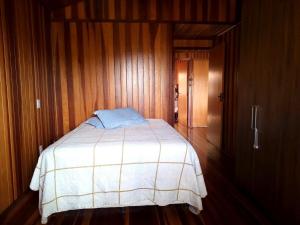 a bedroom with a bed in a wooden room at Casa de Campo in Caldas