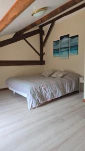 a bed in a room with a wooden ceiling at Le Gite de l'Alambic in Vanzay
