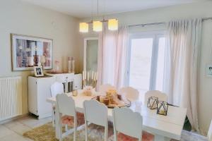 a dining room with a white table and chairs at Fairy home Porto Heli in Porto Heli
