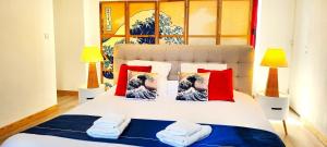 Schlafzimmer mit einem Bett mit roten und blauen Kissen in der Unterkunft Villa Kermohic - en front de mer in Pleubian