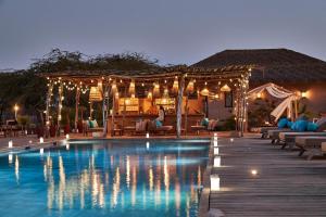 a resort with a swimming pool at night at Yokan Lodge in Palmarin