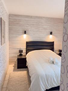 丰罗穆Altitude 1711 - Terrasse en hyper-centre的卧室里有一张白色的床，床上有两条毛巾