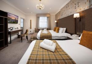 a hotel room with two beds and a desk at New Town Hotel in Edinburgh