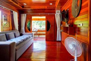 een woonkamer met een bank en een ventilator bij 7Sea Beach Pool Villa in Ao Nam Mao